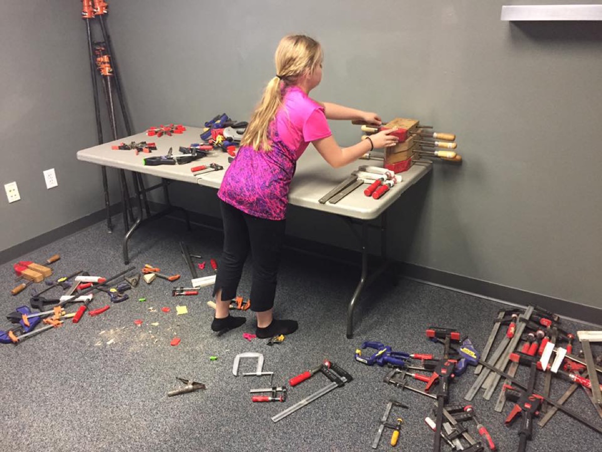 Child organizing hand tools on a table