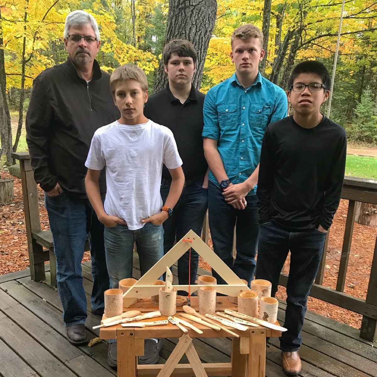 Students with a wooden construction project outdoors