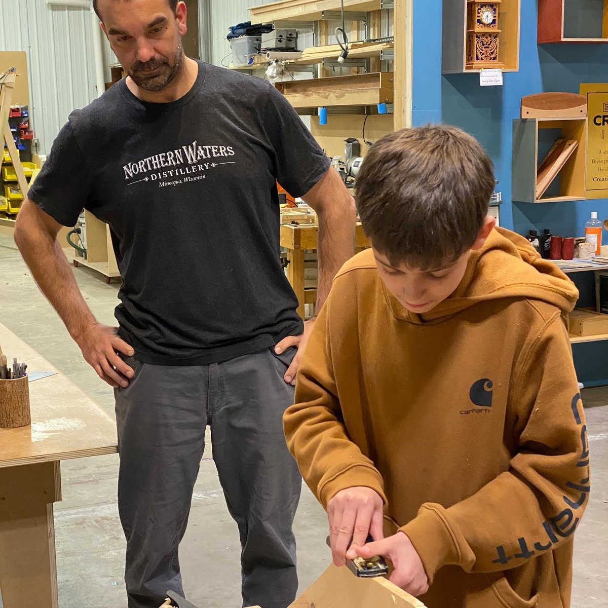 Instructor guiding a student using a hand tool