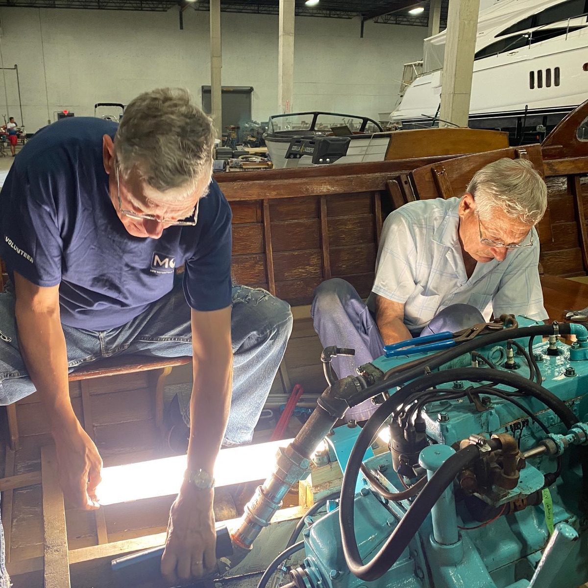 Volunteers working inside a wooden boat