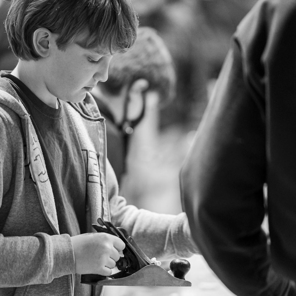 Student carefully shaping a wooden project