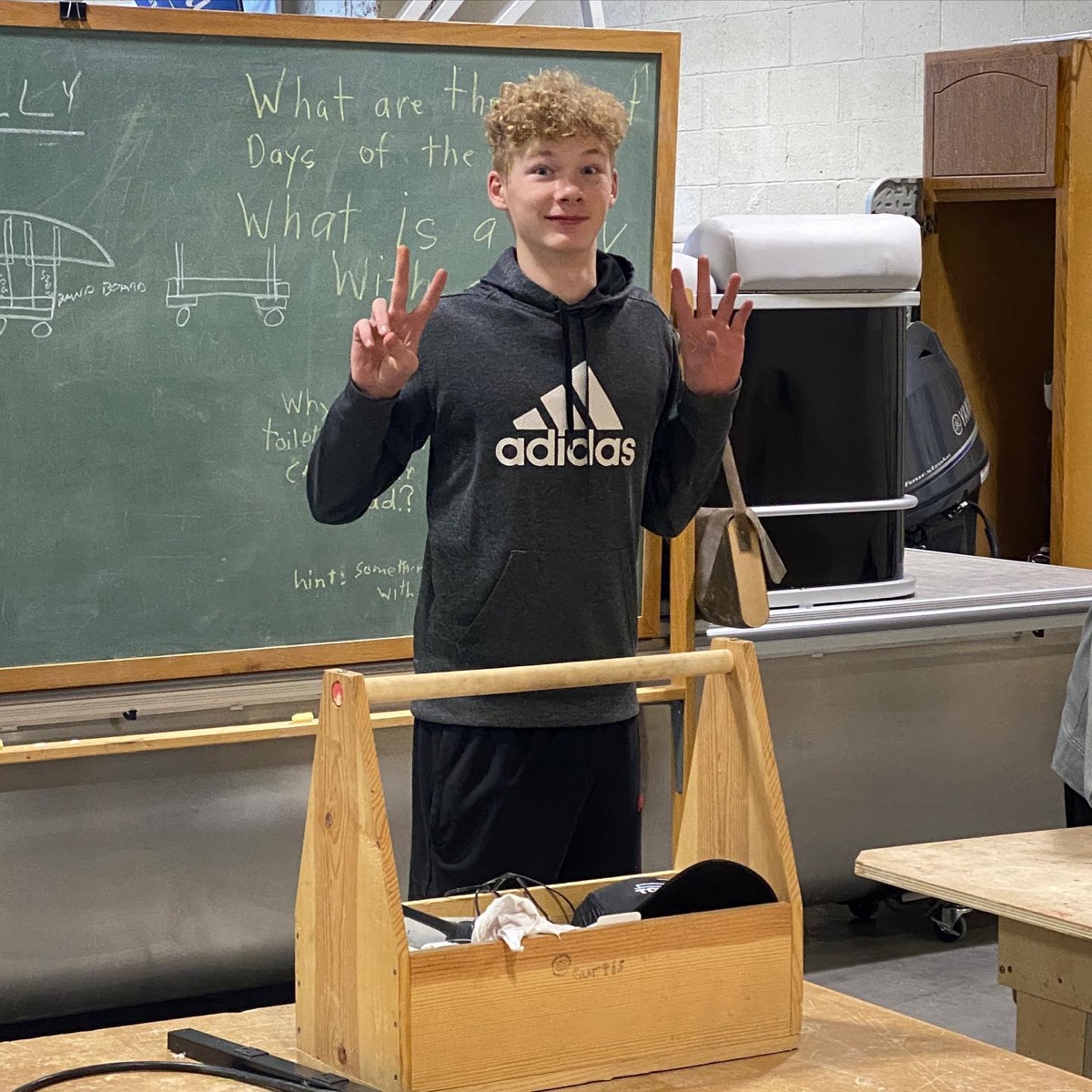 Student displaying a handmade wooden tote