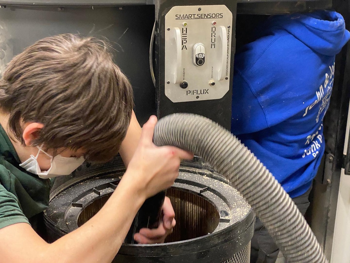 Student helping with workshop dust collection