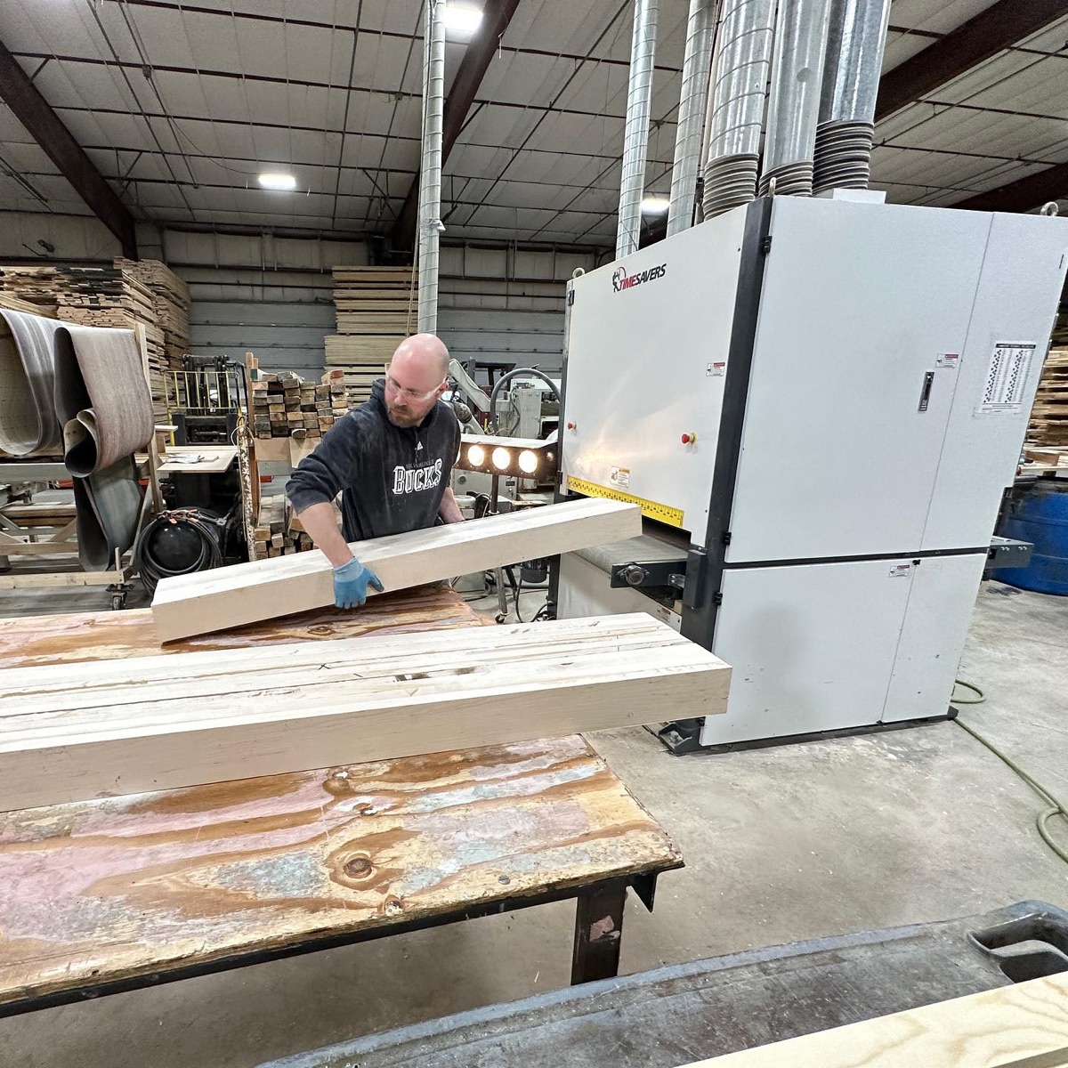 Woodworker preparing lumber at a machine