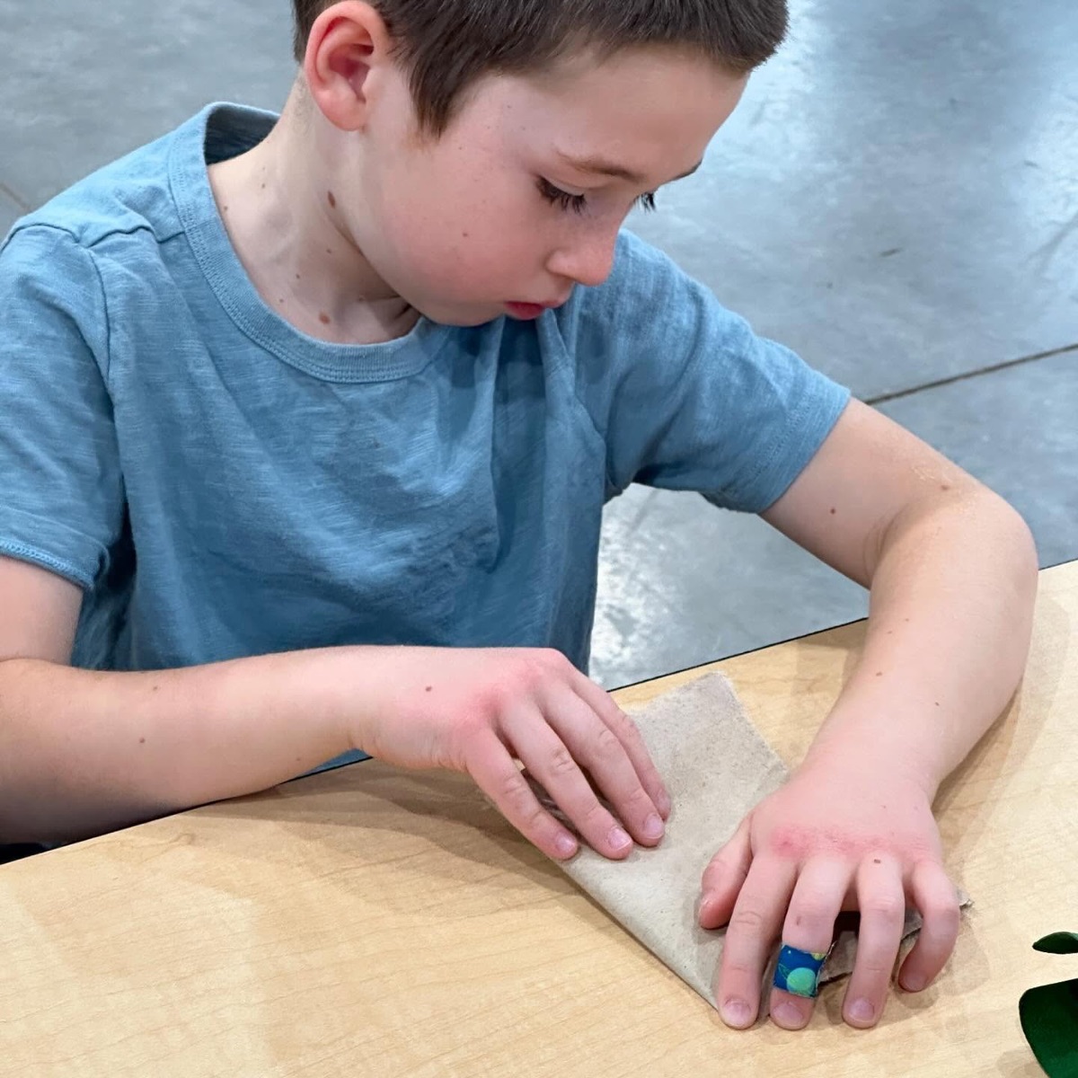 Student sanding wood at a table