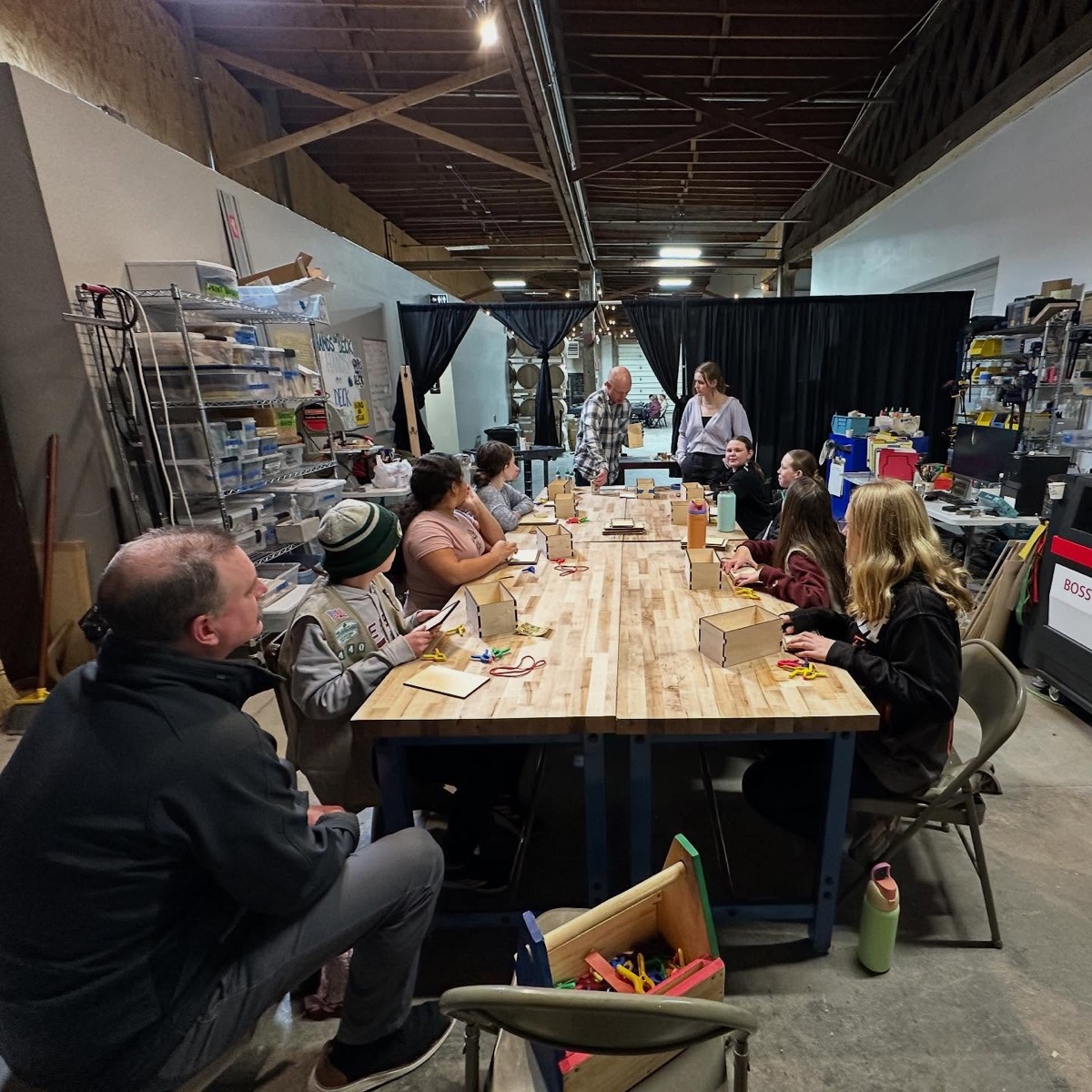 Community gathering around a long workshop table