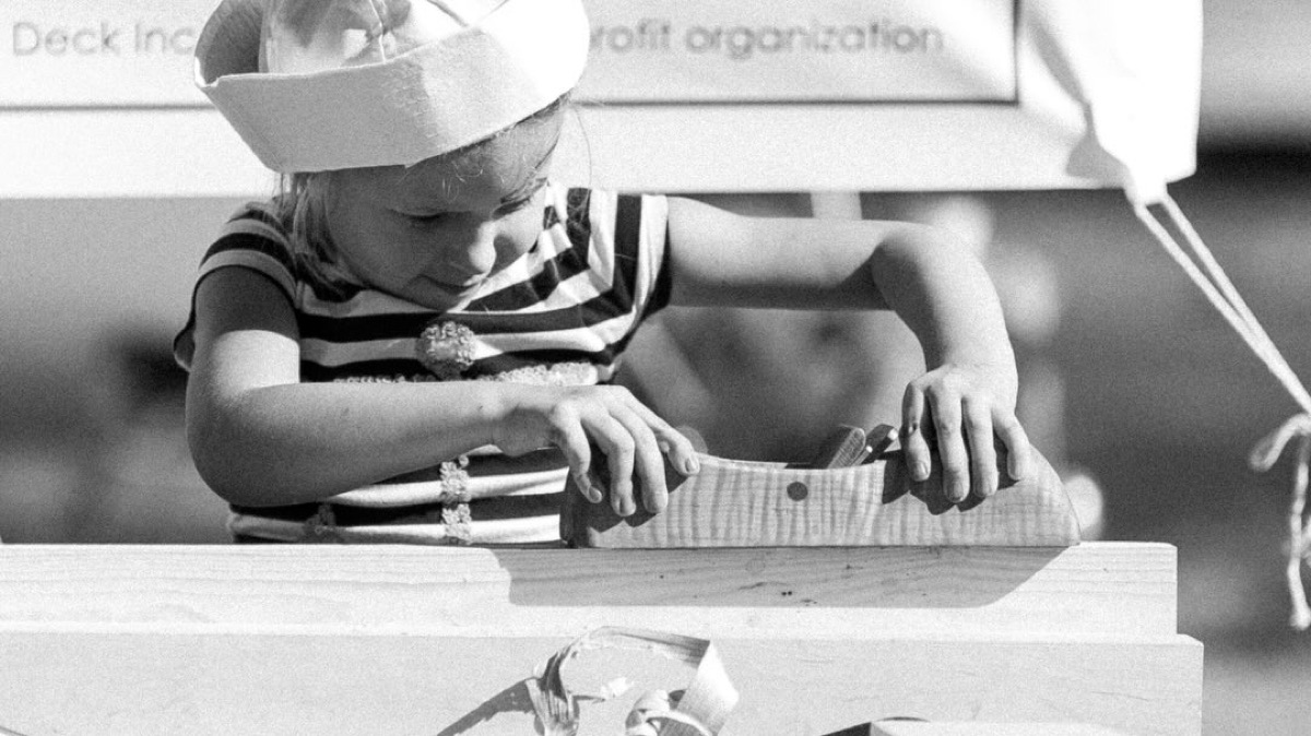 Young child using a hand plane