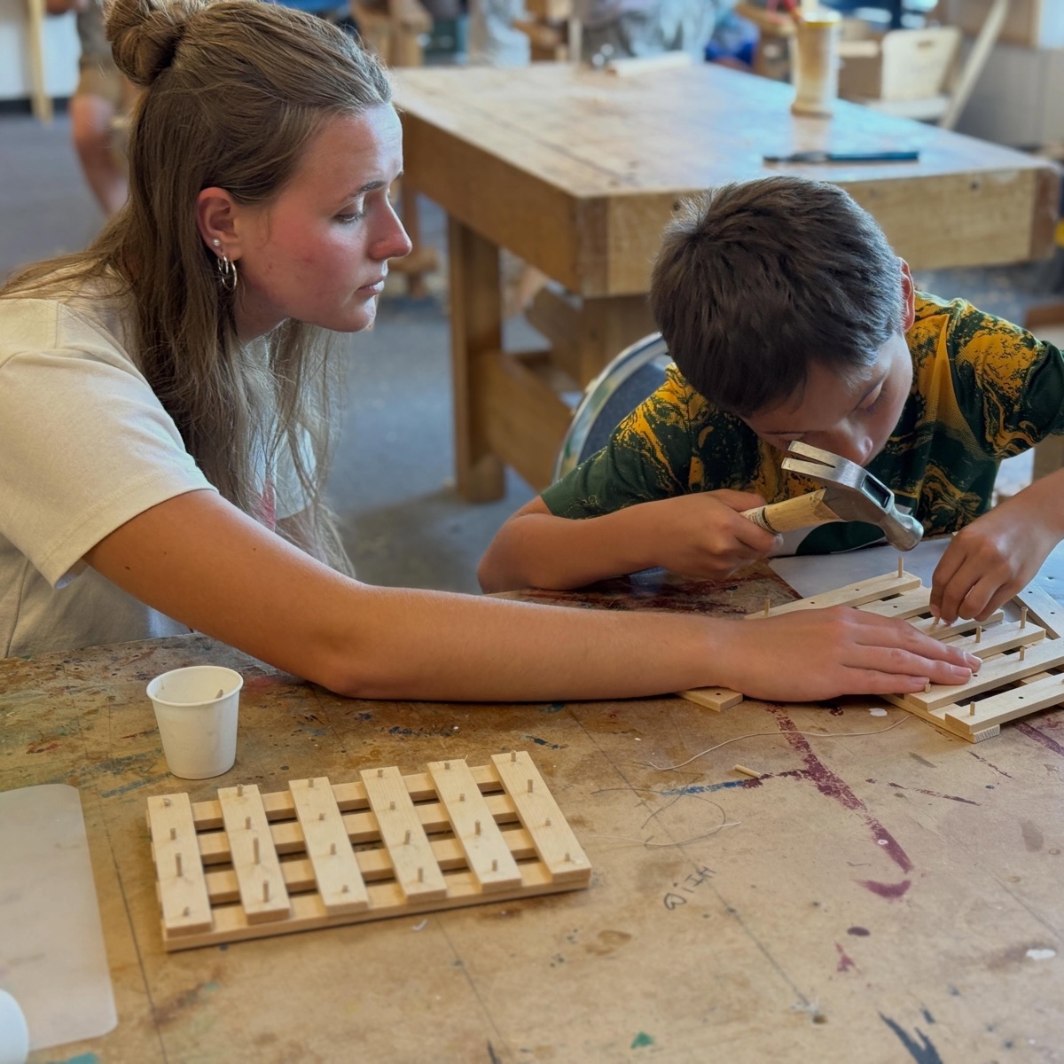 Instructor helping a student at a work table