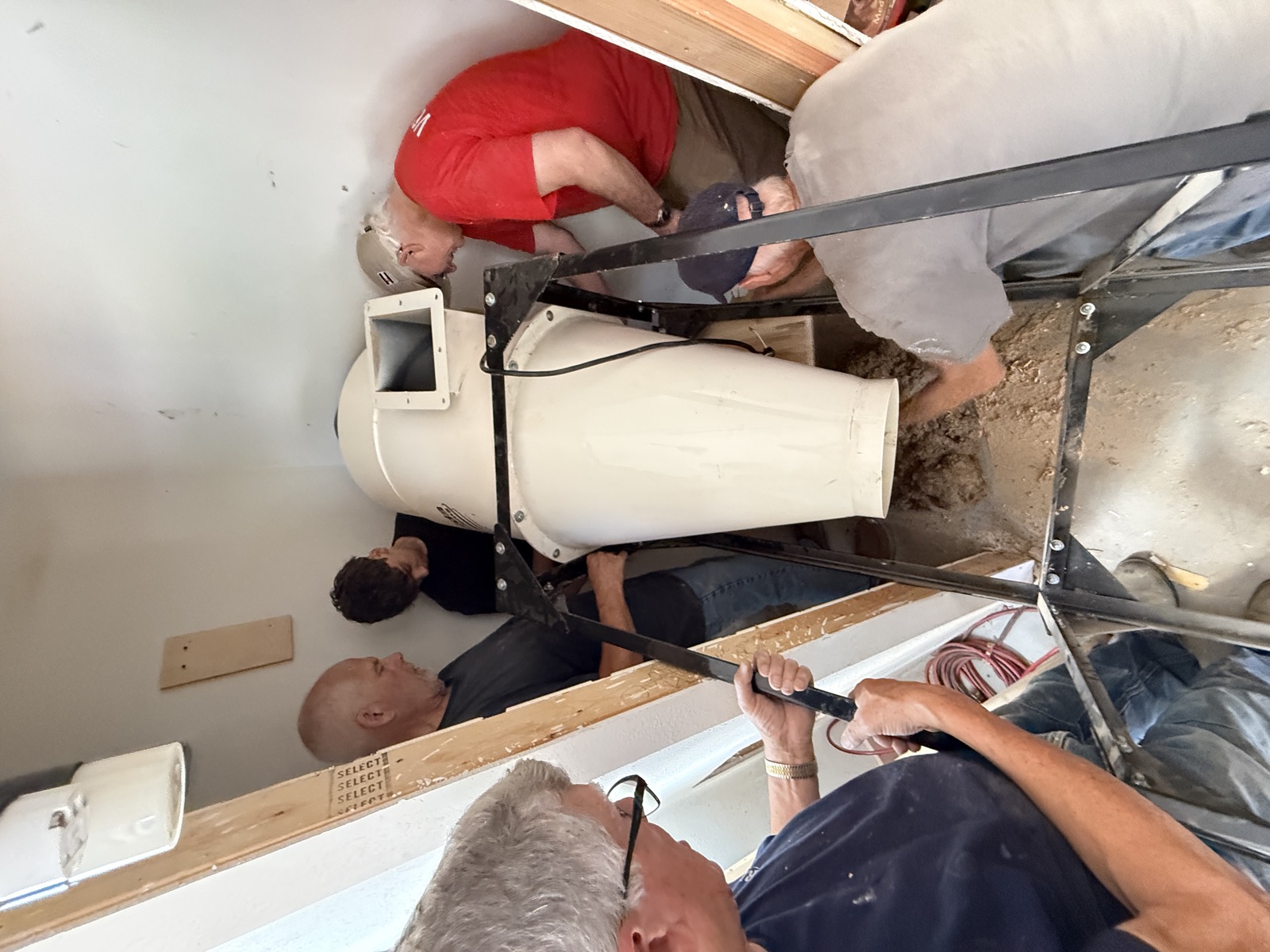 Volunteers working together to move workshop equipment